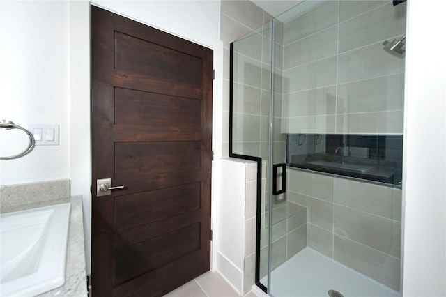 bathroom featuring tile patterned flooring, vanity, and a shower with shower door