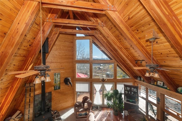 living room featuring vaulted ceiling with beams, wooden walls, ceiling fan, and wooden ceiling