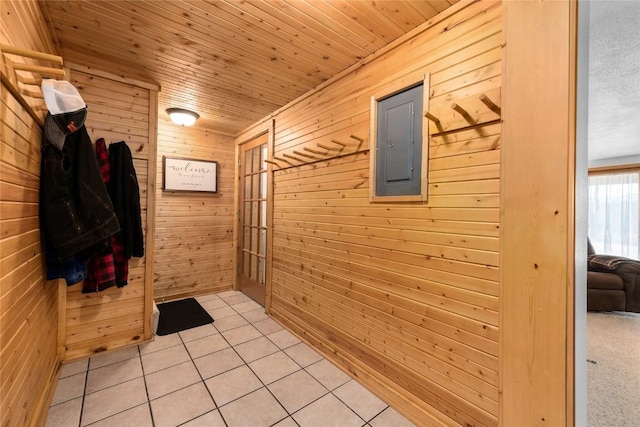 mudroom featuring electric panel, wooden walls, light tile patterned floors, and wooden ceiling