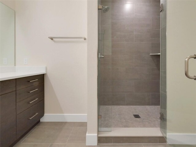 bathroom with vanity, tile patterned floors, and a shower with door