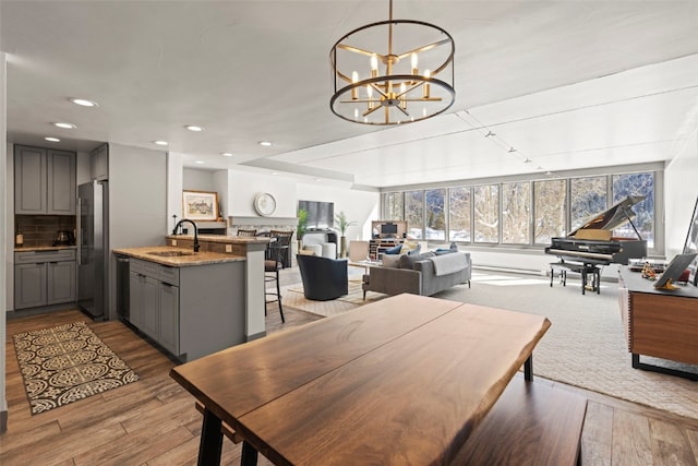 dining space with a chandelier, light wood finished floors, and recessed lighting