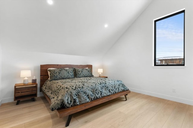 bedroom with light hardwood / wood-style floors and vaulted ceiling