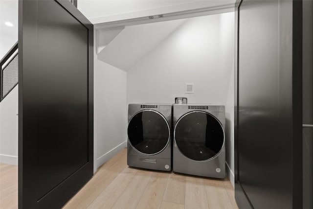 clothes washing area featuring light wood-type flooring and washing machine and clothes dryer