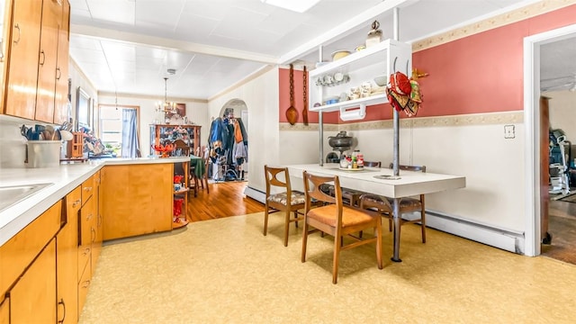 dining room featuring a chandelier, light hardwood / wood-style floors, and a baseboard heating unit