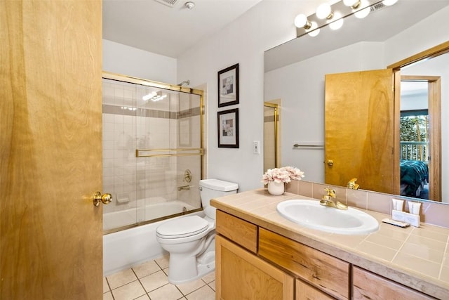 bathroom featuring toilet, tile patterned flooring, bath / shower combo with glass door, and vanity