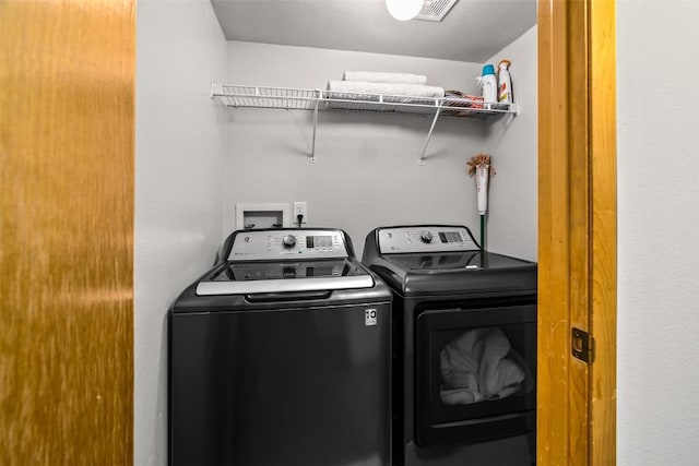 clothes washing area with washer and dryer, laundry area, and visible vents