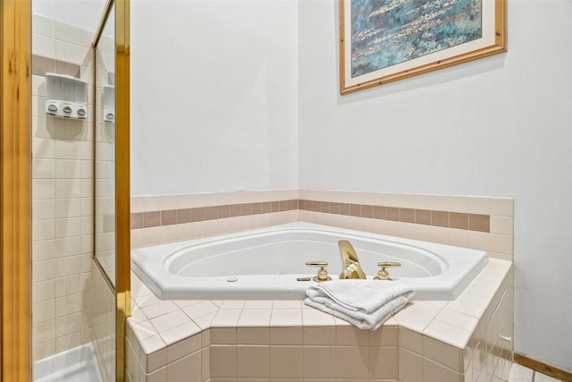 bathroom with a stall shower and a garden tub