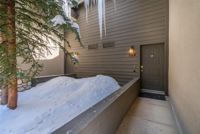 entrance to property featuring stucco siding