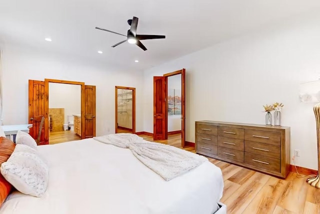 bedroom featuring light wood-type flooring, ensuite bathroom, and ceiling fan