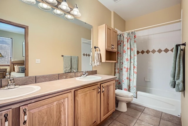 full bath with a sink, double vanity, and tile patterned flooring