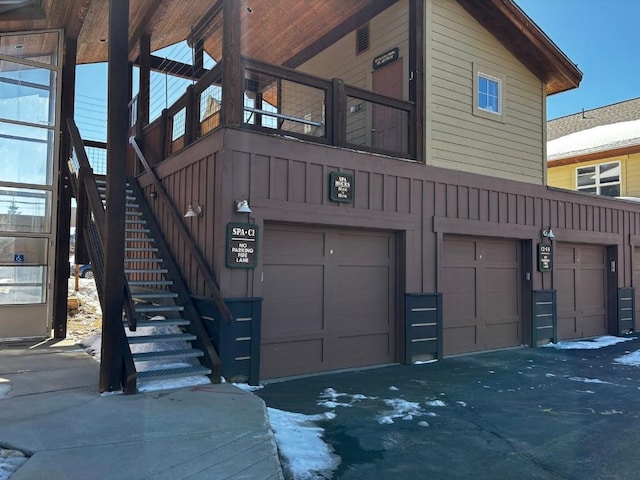 exterior space featuring stairs, an attached garage, and board and batten siding