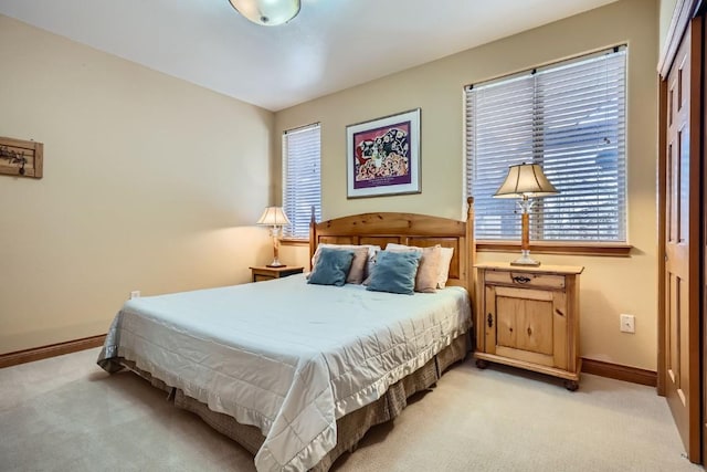 bedroom featuring light carpet and baseboards