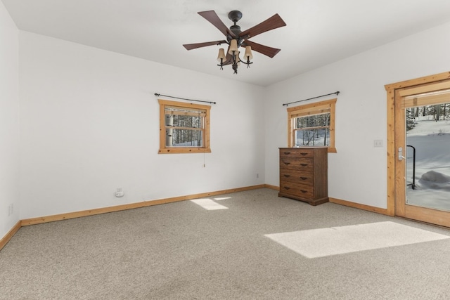 unfurnished bedroom with multiple windows, light colored carpet, access to exterior, and ceiling fan