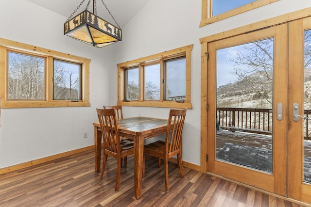 dining area with high vaulted ceiling, dark hardwood / wood-style floors, and french doors