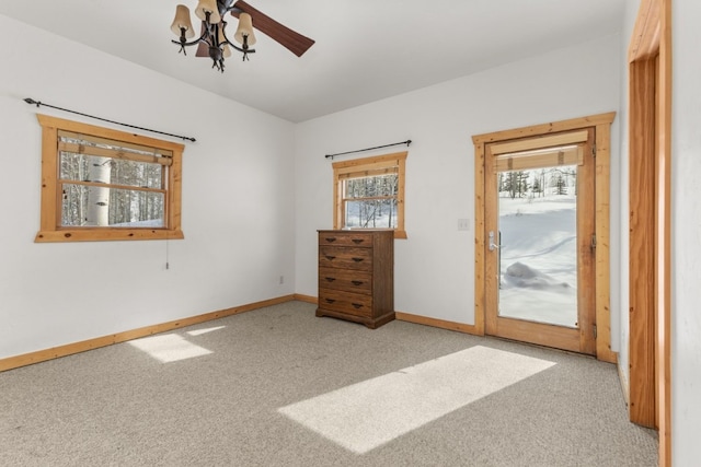 unfurnished bedroom featuring multiple windows, light carpet, ceiling fan, and access to outside