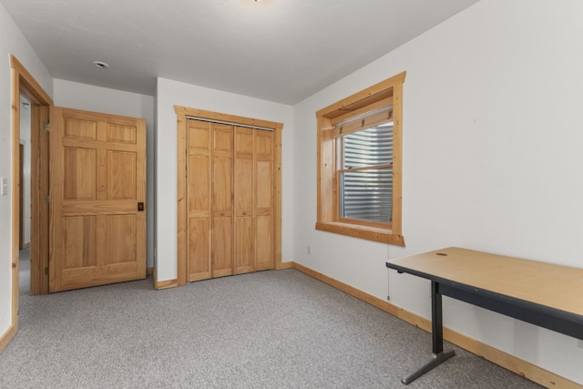 unfurnished bedroom with light colored carpet and a closet