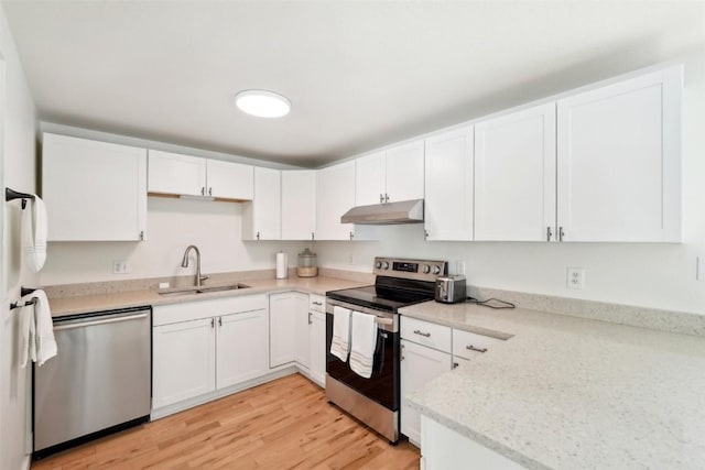 kitchen featuring under cabinet range hood, light wood-type flooring, stainless steel appliances, white cabinetry, and a sink