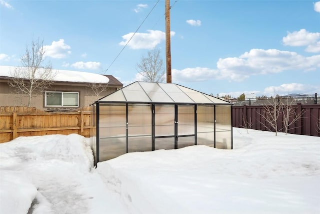 yard covered in snow with an outdoor structure, fence private yard, and an exterior structure