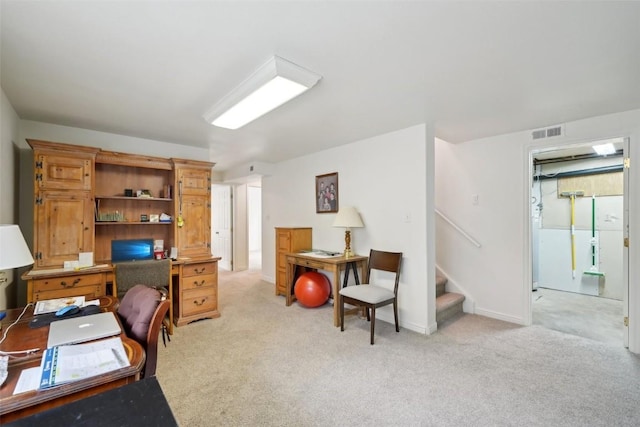 office area with baseboards, visible vents, and light carpet