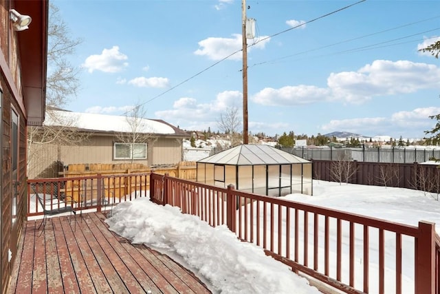 snow covered deck with an outbuilding and a fenced backyard