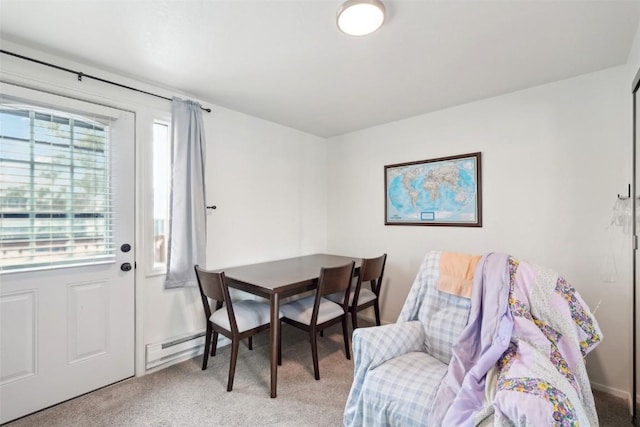 dining space featuring a baseboard heating unit and light colored carpet