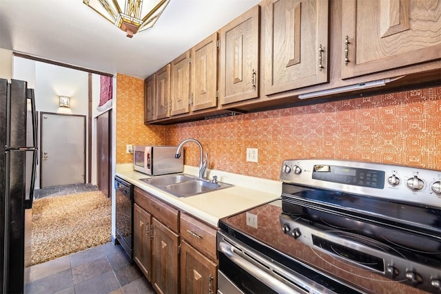 kitchen featuring dark colored carpet, sink, and black appliances