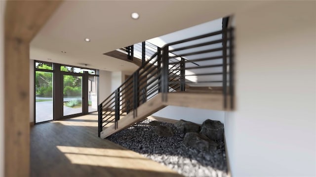 staircase with hardwood / wood-style floors and expansive windows