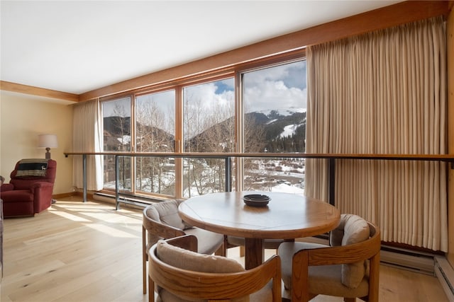 dining area featuring light wood-type flooring and a mountain view