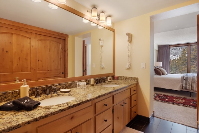 bathroom featuring double vanity, a sink, ensuite bath, and tile patterned floors