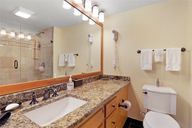 bathroom featuring vanity, a shower stall, toilet, and tile patterned floors