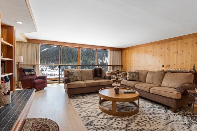 living room with a healthy amount of sunlight, hardwood / wood-style flooring, and wooden walls