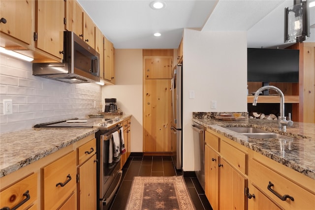 kitchen with recessed lighting, stainless steel appliances, a sink, backsplash, and light stone countertops