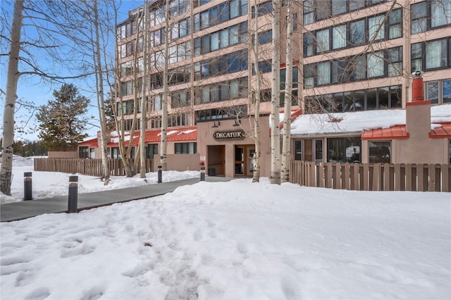 snow covered building featuring fence