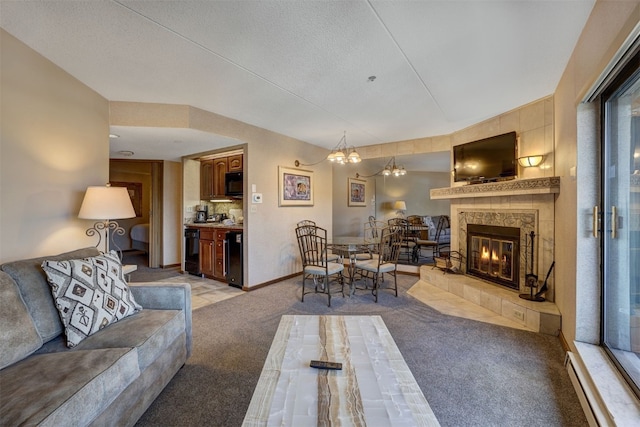 living room featuring light carpet, a notable chandelier, a fireplace, and a baseboard radiator