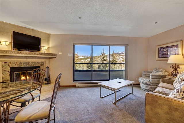 living room with a mountain view, a tiled fireplace, light carpet, and a textured ceiling