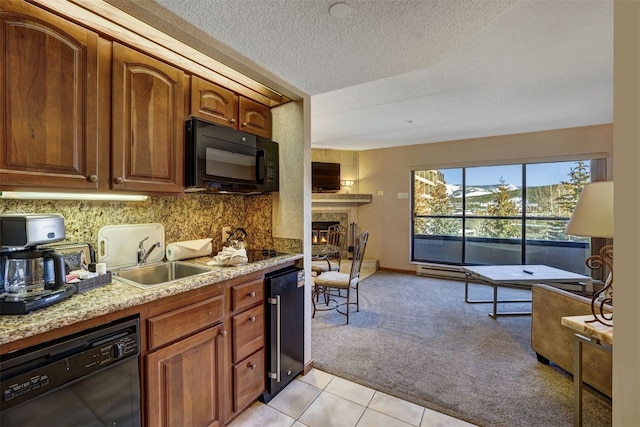 kitchen with sink, backsplash, light stone counters, black appliances, and light carpet