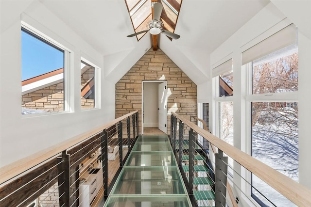 hallway with lofted ceiling with beams and an upstairs landing