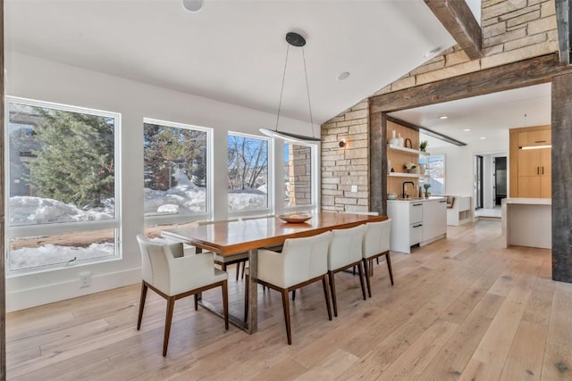 dining area with lofted ceiling with beams and light wood-style floors