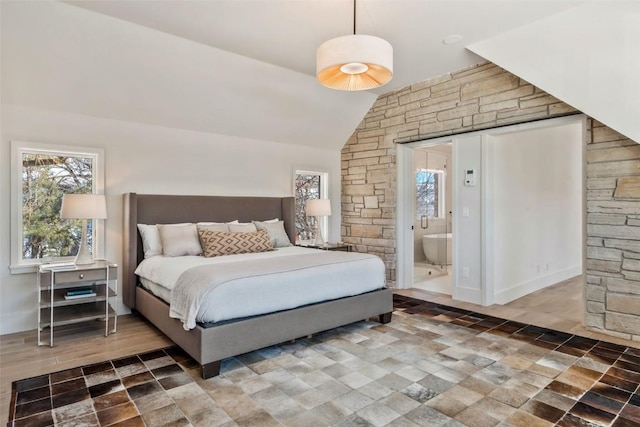 bedroom with vaulted ceiling and connected bathroom