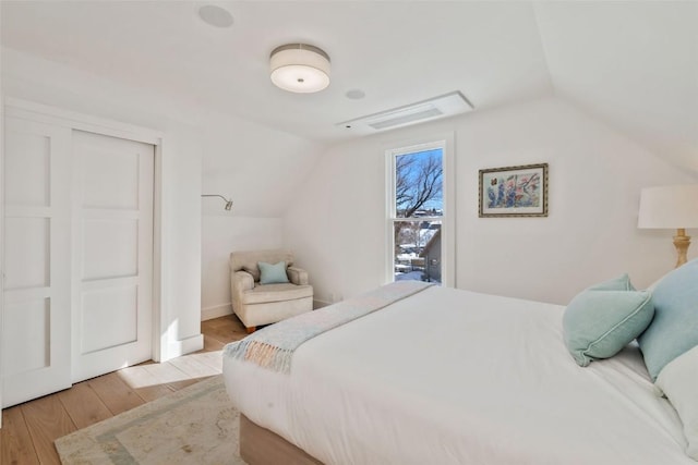 bedroom with vaulted ceiling and wood finished floors