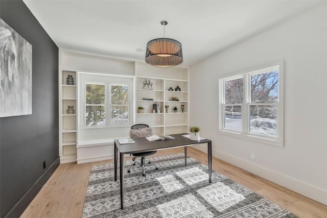 office area with baseboards and wood finished floors