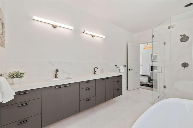 full bathroom with double vanity, a freestanding tub, a sink, and a marble finish shower