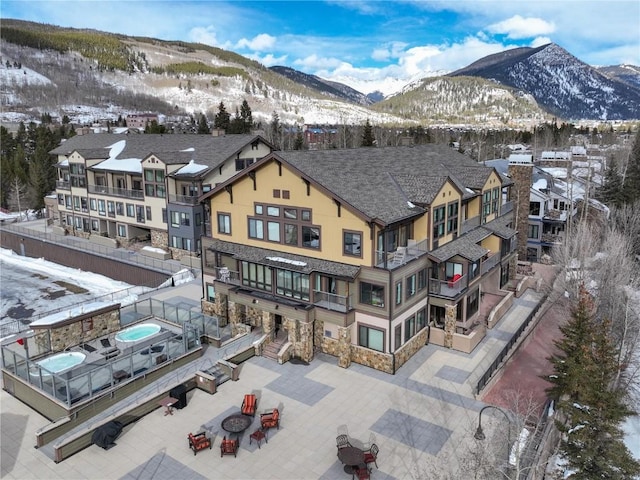 snowy aerial view with a residential view and a mountain view