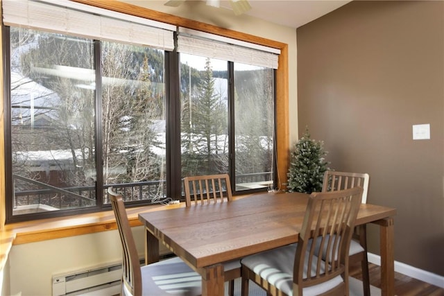 dining space with a baseboard heating unit, ceiling fan, and baseboards