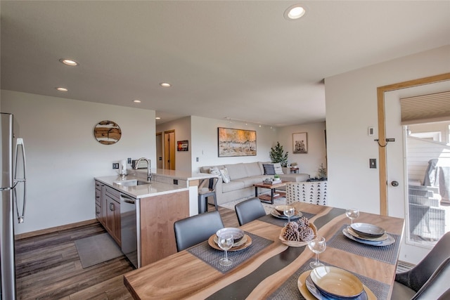 dining area featuring sink and dark hardwood / wood-style flooring