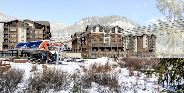 snow covered building featuring a mountain view