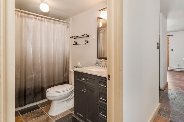 full bathroom featuring baseboards, toilet, stone tile flooring, vanity, and a baseboard heating unit