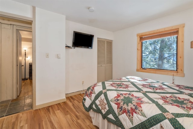 bedroom featuring a closet, wood finished floors, and baseboards