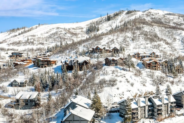 snowy aerial view featuring a residential view and a mountain view