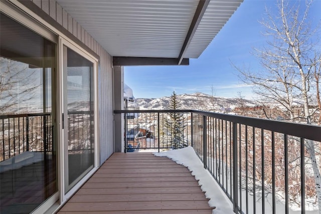 snow covered back of property with a mountain view